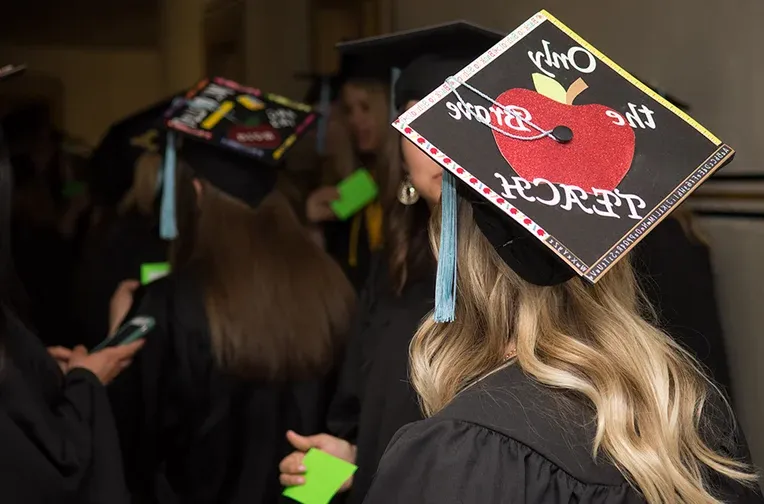 学生戴着写着“勇者教书”的毕业帽